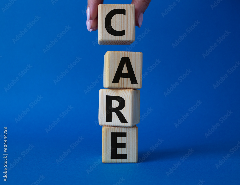 Care symbol. Concept word Care on wooden cubes. Businessman hand. Beautiful blue background. Business and Care concept. Copy space. Care symbol. Concept word Care on wooden cubes. Businessman hand. Beautiful blue background. Business and Care concept. Copy space.