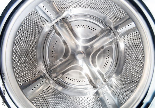 Inside of washing machine. Rotating inner tub. Material metal. Close-up of electrical household appliance.