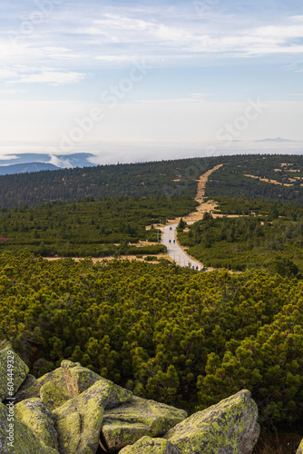 Beautiful landscape of hills and mountains full of green bushes, yellow grass and big rocks at sunny autumn day photo