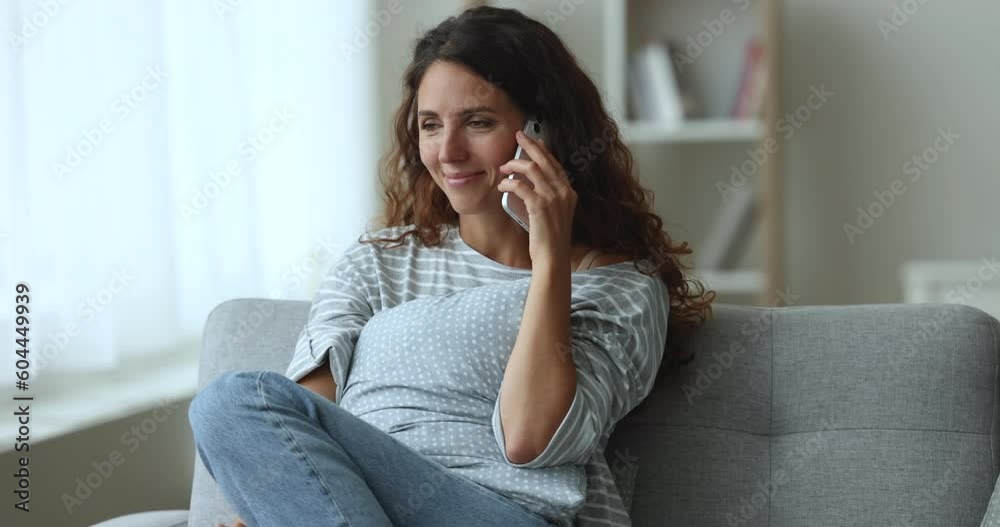 Carefree Hispanic woman relaxing on couch, spend free time at home, enjoy personal conversation on cell phone, communicates remotely with boyfriend, share news, use modern tech and mobile connection Carefree Hispanic woman relaxing on couch, spend free time at home, enjoy personal conversation on cell phone, communicates remotely with boyfriend, share news, use modern tech and mobile connection