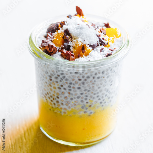 chia and coconut pudding with mango mousse and cacao beans