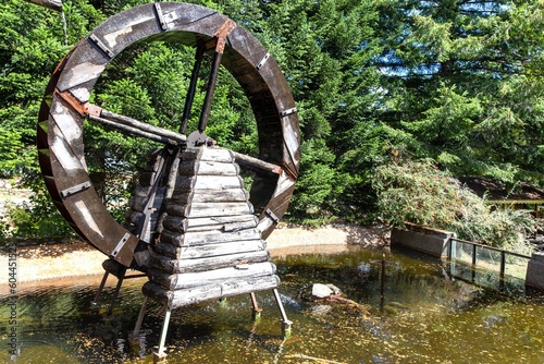 Old Wooden Mill Wheel, Treelined Water Pond Lagoon.  Sunny Day, Puerto Peulla Lago Todos Los Santos, Latin America, Chile photo