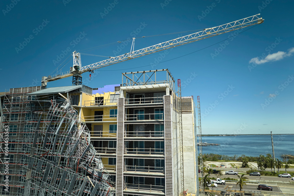Aerial view of ruined by hurricane Ian construction scaffolding on high apartment building site in Port Charlotte, USA