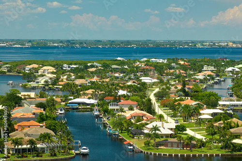 Aerial view of residential suburbs with private homes located on gulf coast near wildlife wetlands with green vegetation on sea shore. Living close to nature concept