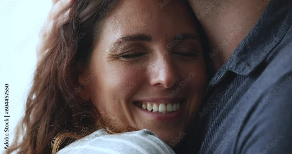 Close up face of beautiful serene Hispanic woman enjoy cuddles, snuggles to her beloved man, his hand strokes her head with tenderness, showing love, gives protection and support. Relations, harmony