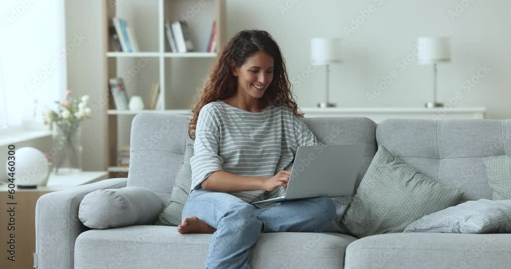 Hispanic young woman rest in living room with laptop on laps, spend free weekend time at home enjoy on-line communication, chatting in social media, share news my messaging with friends, make orders Hispanic young woman rest in living room with laptop on laps, spend free weekend time at home enjoy on-line communication, chatting in social media, share news my messaging with friends, make orders