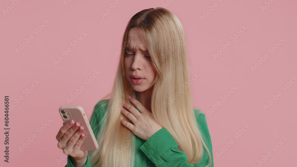 Caucasian woman use mobile cell phone typing browsing, loses becoming surprised sudden lottery results, bad fortune, loss, fail. Pretty one girl isolated alone on pink studio wall background, indoors Caucasian woman use mobile cell phone typing browsing, loses becoming surprised sudden lottery results, bad fortune, loss, fail. Pretty one girl isolated alone on pink studio wall background, indoors