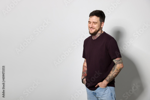 Smiling hipster man on light grey background. Space for text