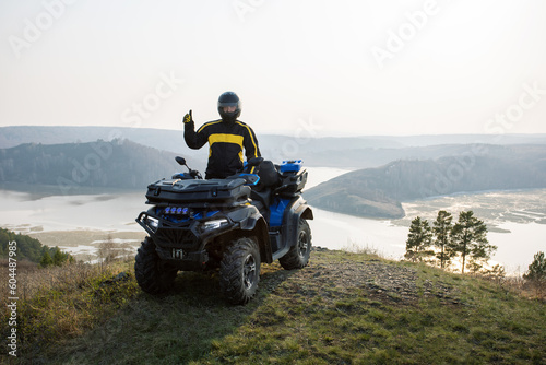 Happy man travel by ATV car on mountains.