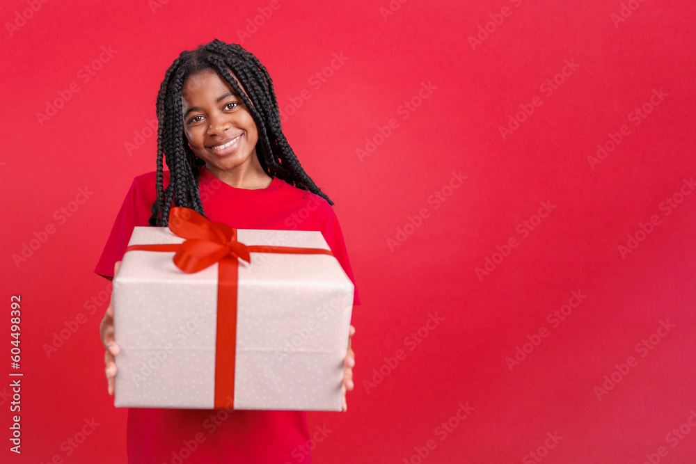 Happy african woman looking at the camera giving a present Happy african woman looking at the camera giving a present