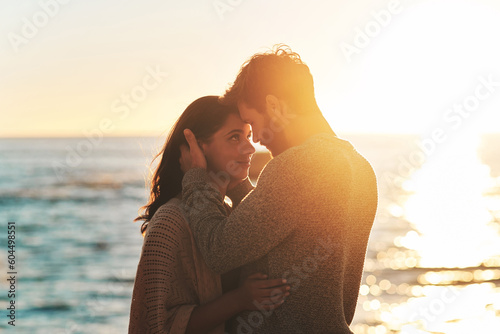 Sunset  beach and couple touching face for relaxing  bonding and quality time on romantic date. Nature  love and man and woman embrace for anniversary or honeymoon on holiday  weekend and vacation