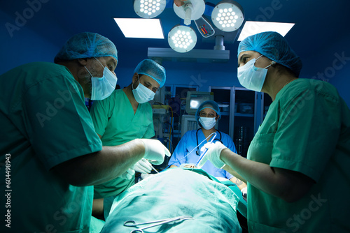 ndian surgeons medical team performing surgery in operation theater at hospital. Medical care concept.