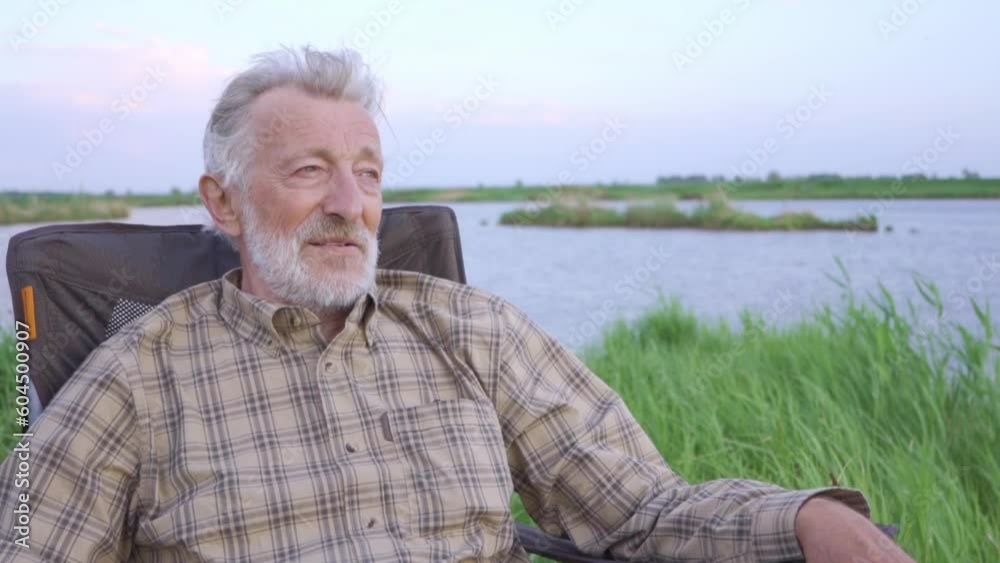 old relaxed fisherman sitting on bank of river, lake enjoying picturesque wonderful nature, landscape alone, relaxing resting time Lifestyle Freedom Happy retirement old relaxed fisherman sitting on bank of river, lake enjoying picturesque wonderful nature, landscape alone, relaxing resting time Lifestyle Freedom Happy retirement