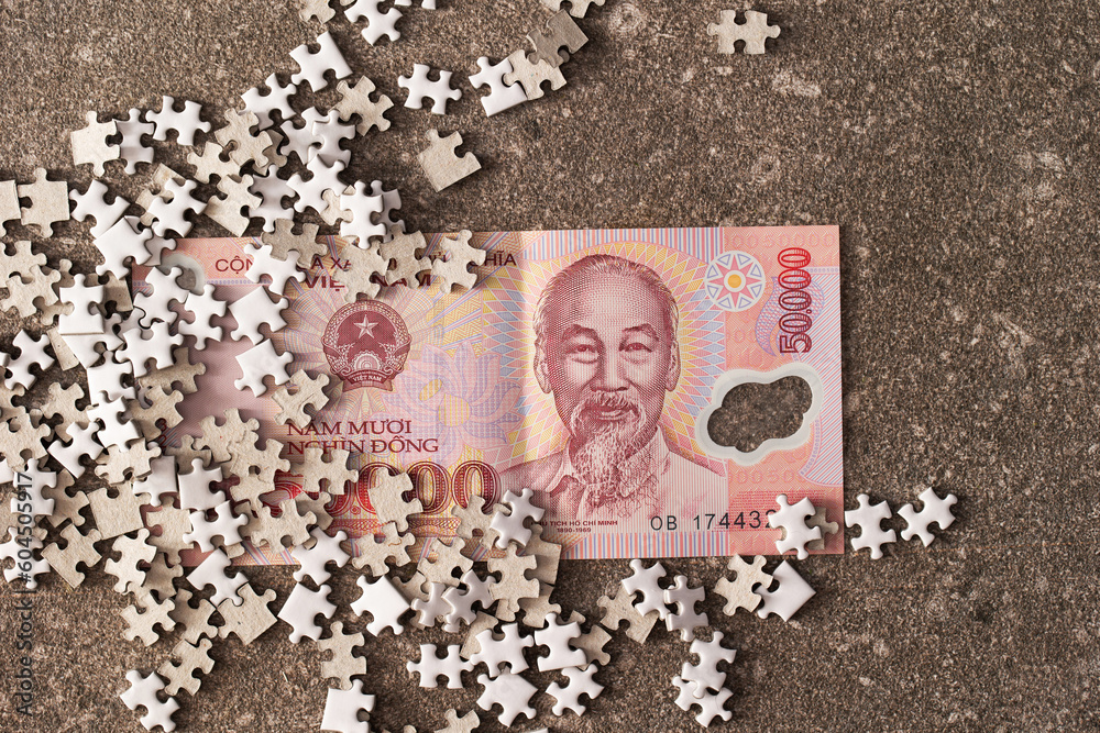 Naklejka premium Vietnamese banknotes and jigsaw puzzle