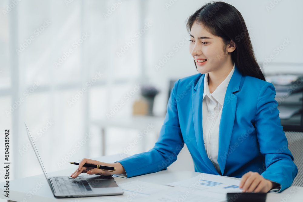 Asian Business woman using calculator and laptop for doing math finance on an office desk, tax, report, accounting, statistics, and analytical research concept Asian Business woman using calculator and laptop for doing math finance on an office desk, tax, report, accounting, statistics, and analytical research concept