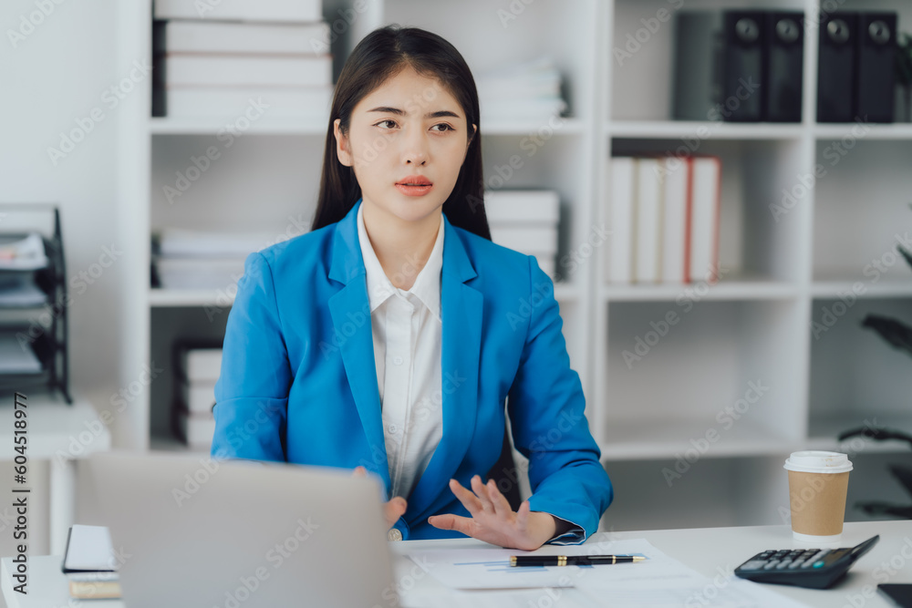 Asian Business woman using calculator and laptop for doing math finance on an office desk, tax, report, accounting, statistics, and analytical research concept Asian Business woman using calculator and laptop for doing math finance on an office desk, tax, report, accounting, statistics, and analytical research concept