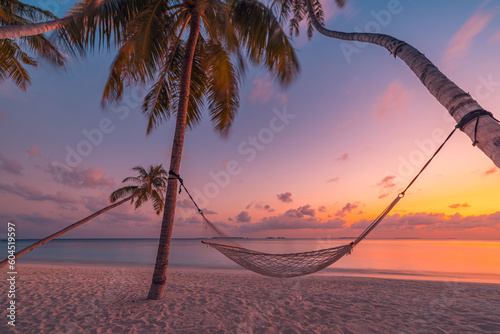 Fototapeta Naklejka Na Ścianę i Meble -  Beautiful silhouette of hammock on palm trees on tropical beach paradise at sunset. Carefree freedom concept, summer nature, exotic shore coast. Tranquil travel landscape. Enjoy life, positive energy