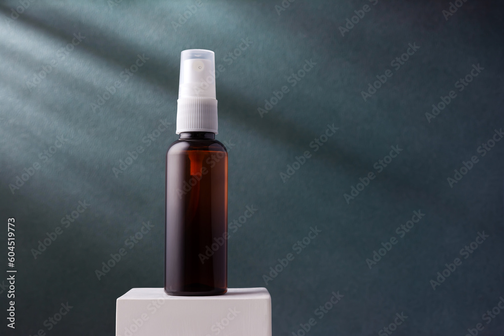 Naklejka premium Cosmetic brown bottle with sprayer on blue background