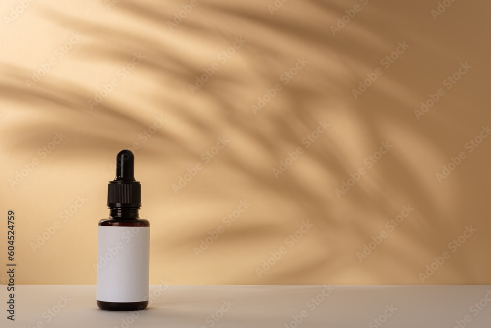 Brown cosmetic dropper bottle with shadow of palm leaves for mock-up Brown cosmetic dropper bottle with shadow of palm leaves for mock-up