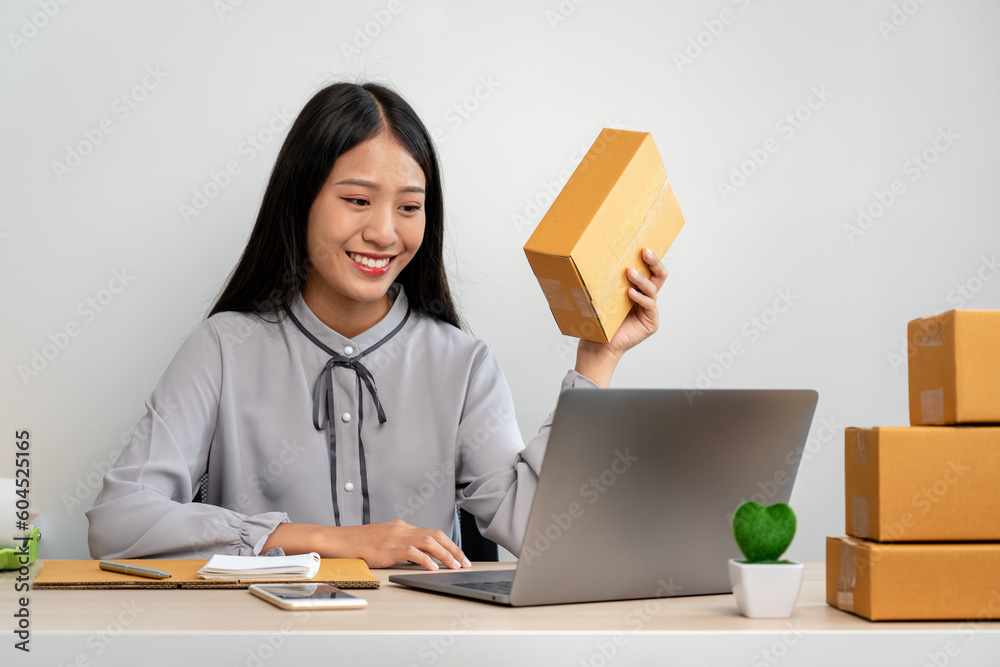 Young woman small business entrepreneur working at home recieve ordering from online customer and checking data while preparing to packing product deliver sending to client Young woman small business entrepreneur working at home recieve ordering from online customer and checking data while preparing to packing product deliver sending to client