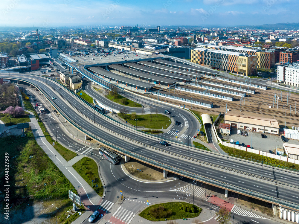 Krakow, Poland. Cityscape with Main railroad station with big parking lot on its roof. Elevated city highway with junctions, rotary and ramps. Old town far view with main monuments in the background