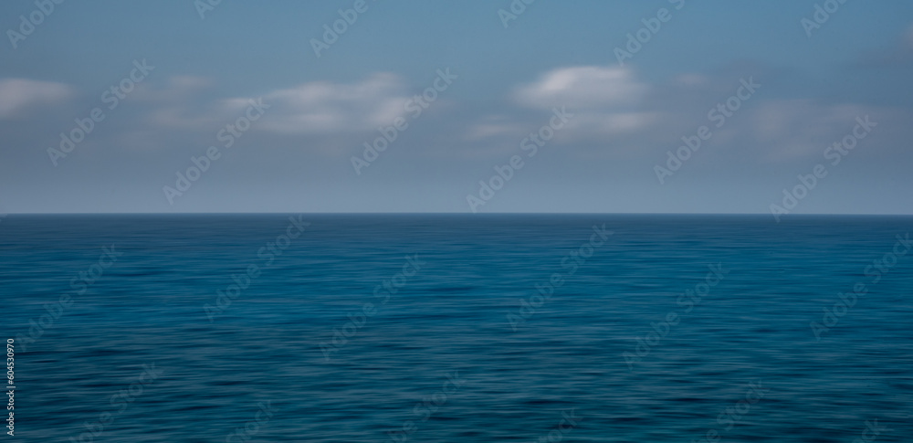 Panoramic seascape with clouds on the horizon. Blurry ocean seascape, serene and peaceful.