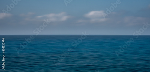 Panoramic seascape with clouds on the horizon. Blurry ocean seascape, serene and peaceful.