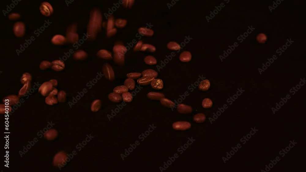 Roasted Arabica coffee beans are spilled and rotated, close-up, brown beans falling to be filled into bags. Roasted Arabica coffee beans are spilled and rotated, close-up, brown beans falling to be filled into bags.