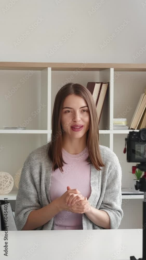 Vertical video. Influencer vlog. Live streaming. Online communication. Smiling friendly woman recording blog making internet content greeting followers speaking home interior.