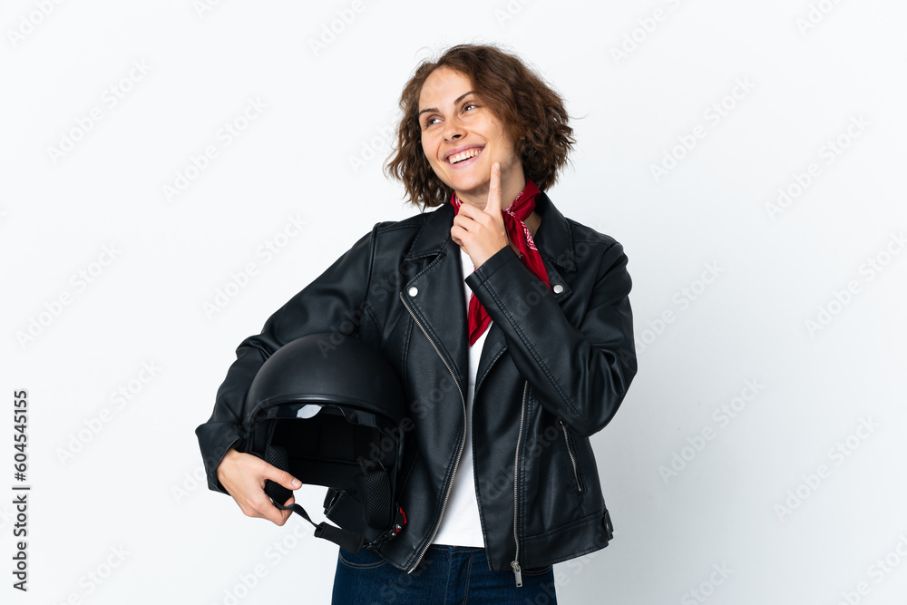 English woman holding a motorcycle helmet isolated on white background thinking an idea while looking up