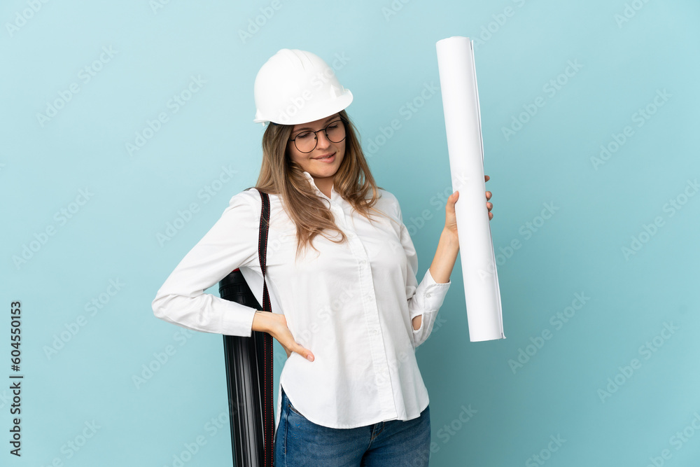 Slovak architect girl holding blueprints isolated on blue background suffering from backache for having made an effort