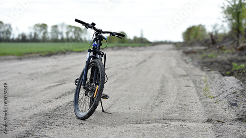 Mountain bike. stands on a field road. spring or autumn. concept of cycling, repair or breakage, sports, outdoor activities. bike on trail, front wheel in focus. healthy lifestyle