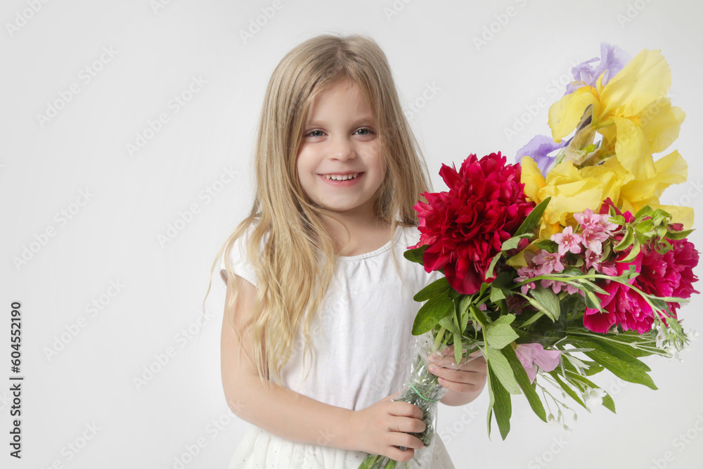 
Studio portrait of beautiful little girl holding big colorful bouquet of various flowers.