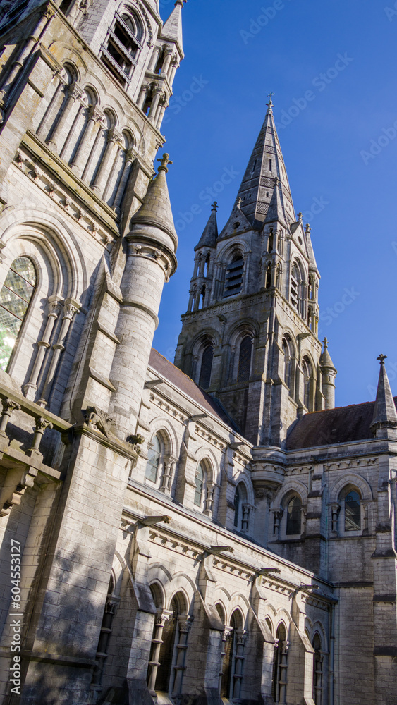 The tall Gothic spire of an Anglican church in Cork, Ireland. Neo-Gothic religious architecture. Cathedral Church of St Fin Barre, Cork - One of Ireland’s Iconic Buildings.