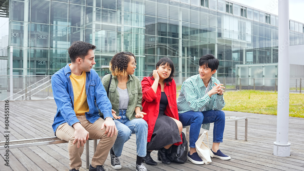 Fototapeta premium ベンチに座って話す多国籍学生グループ
