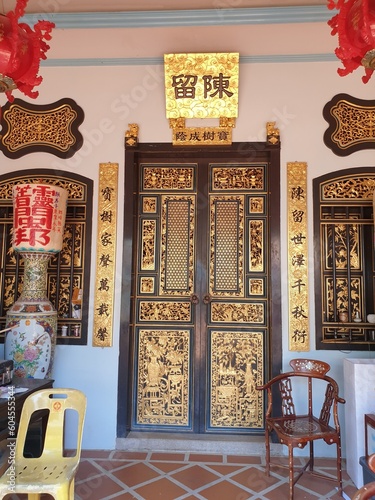 Photo of a door in a Chinese temple, in golden tones.