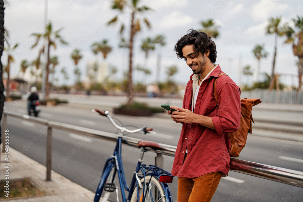 Fotografie A happy man using mobile app on the street.