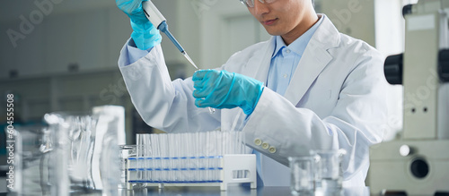A man in a white coat experimenting in a laboratory. photo