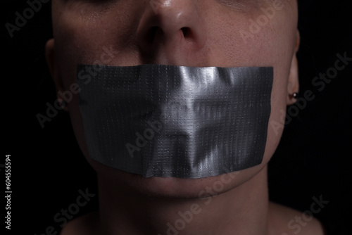 Fotografi Close up of woman's taped mouth, concept of violence, freedom of speech