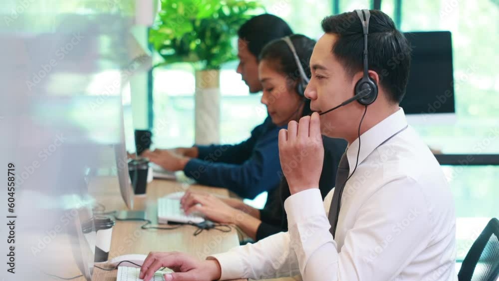 Call center and one stop service. Attractive business Asian man headsets working with desktop computer at telemarketing customer service agents Call center and one stop service. Attractive business Asian man headsets working with desktop computer at telemarketing customer service agents