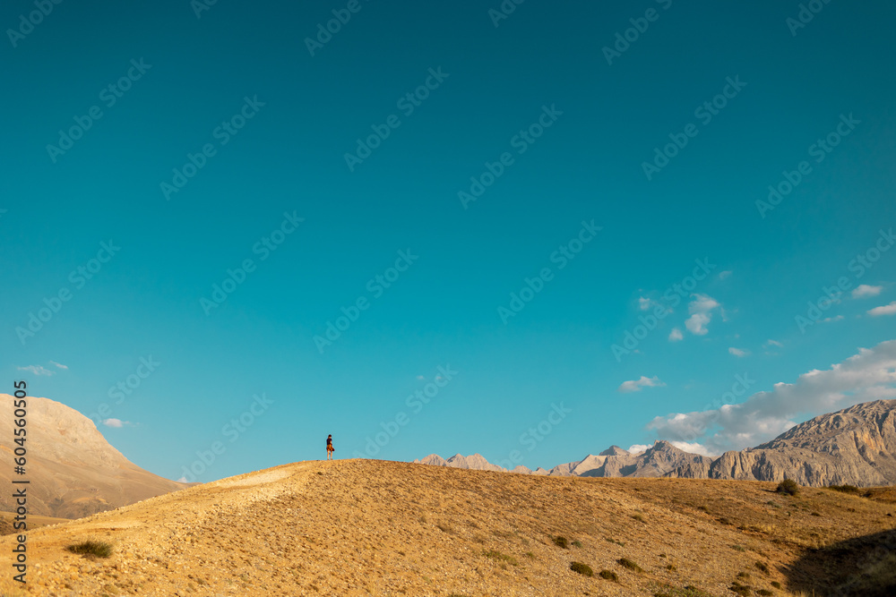 Hiking in the mountains. The girl is walking along a mountain path. Hiking in the mountains. The girl is walking along a mountain path.