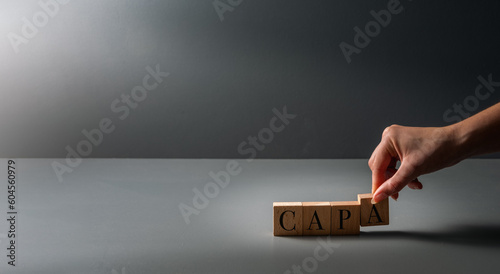 Fotografia hand posing wooden blocks ,CAPA , acronym for corrective and preventive action ,