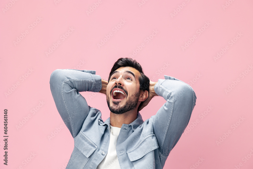 Fashion portrait of a brunette man with a beard happiness victory raised his hands with his fist up on a pink background in a white T-shirt smile and joyful emotion on his face, copy space Fashion portrait of a brunette man with a beard happiness victory raised his hands with his fist up on a pink background in a white T-shirt smile and joyful emotion on his face, copy space
