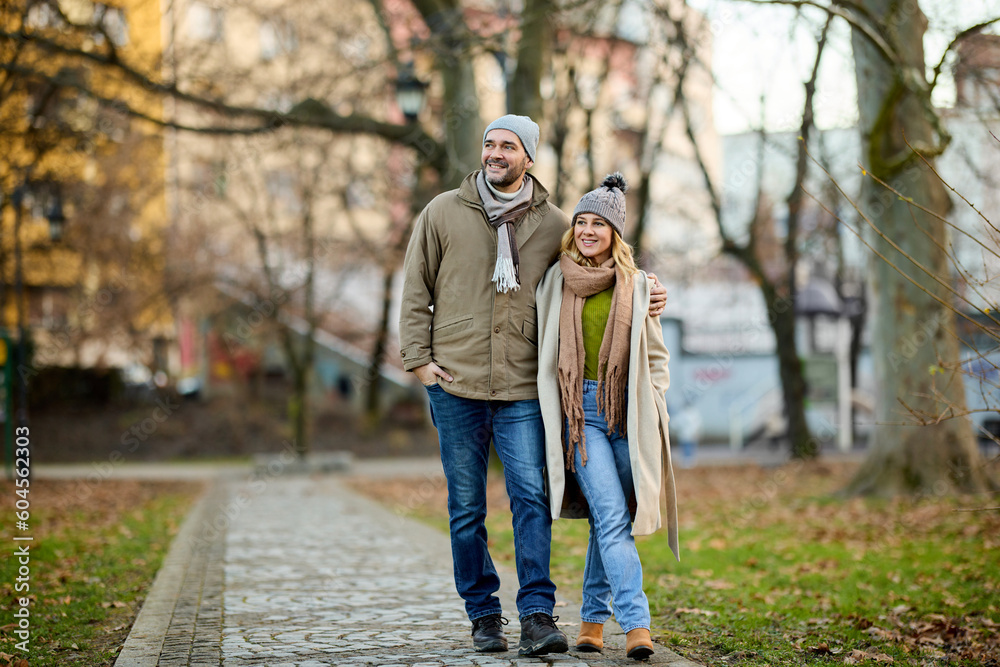 Embraced romantic couple enjoying a walk in the park Embraced romantic couple enjoying a walk in the park