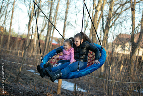 2 girls swinging on a swing
