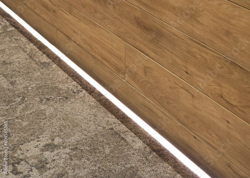 Fotografi Wooden fiber cement wall with carpet floor and indirect lighting.