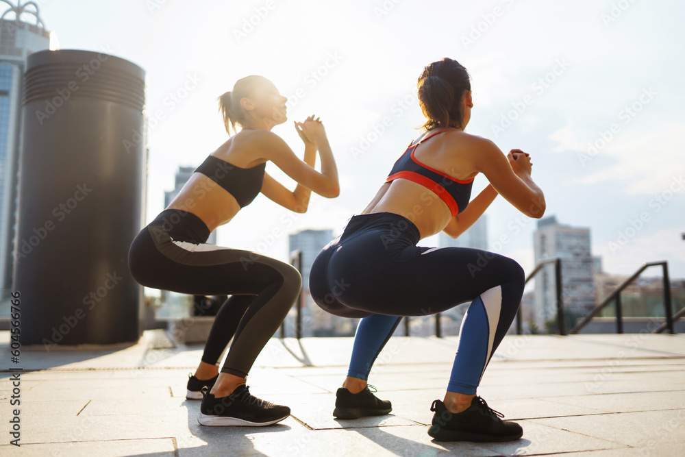 Two Young woman in sports outfit doing exercises outdoors in the morning.  Sport, Active life, sports training, healthy lifestyle.