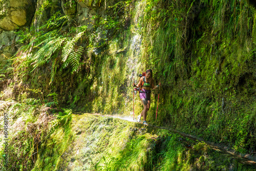 Photo of a long hair blond beautiful girl going under the waterfall in Madeira island.
