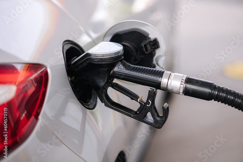 Car refueling at gas station. Petrol pump filling fuel nozzle in fuel tank of car at gas station. Petrol crisis concept.