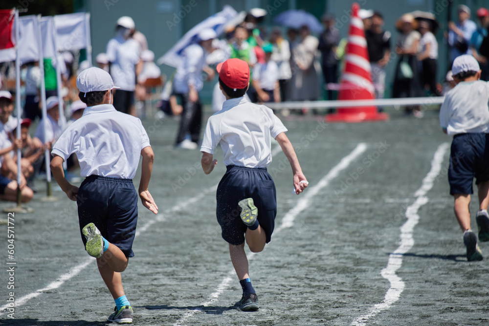 小学校の運動会で短距離走をしている学生達の後ろ姿